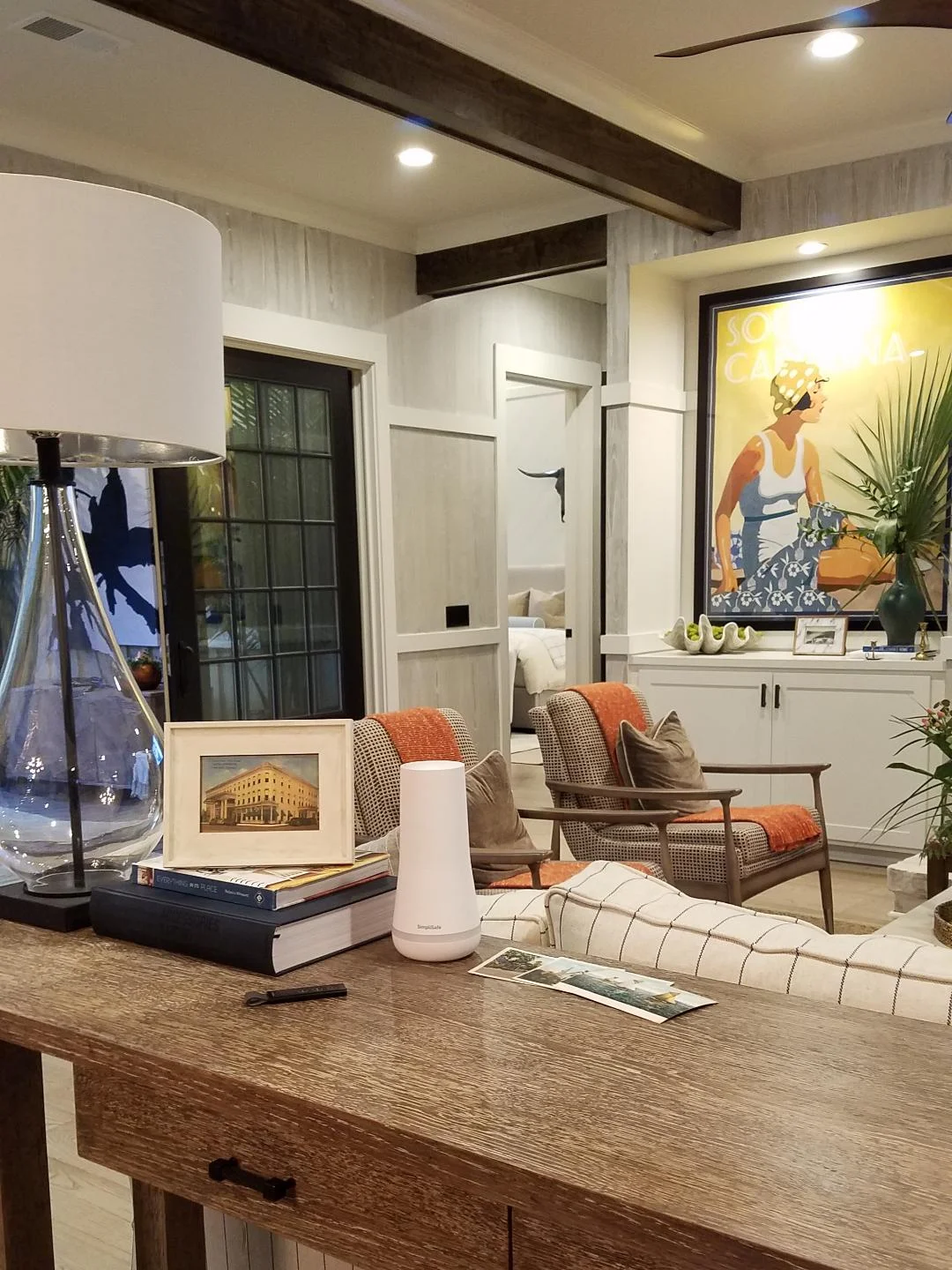 The white device on this console next to the books is the SimpliSafe base station; the SimpliSafe key fob, which allows you to disarm your system before you enter your house, is in front of it.