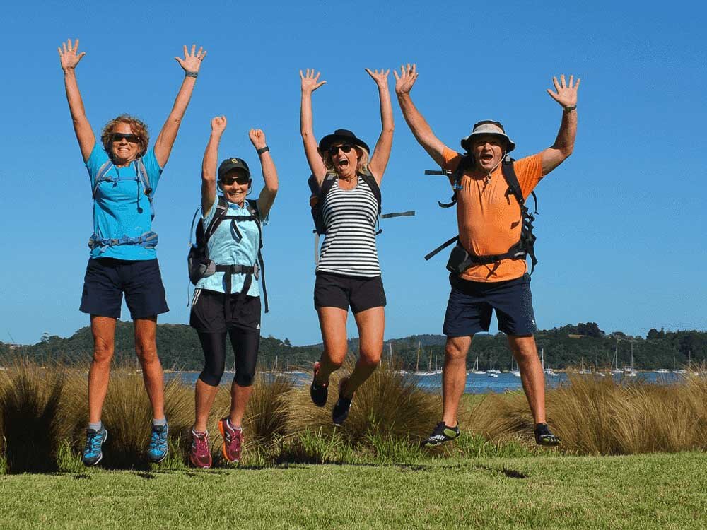 Happy walkers jumping Waiheke Island New Zealand