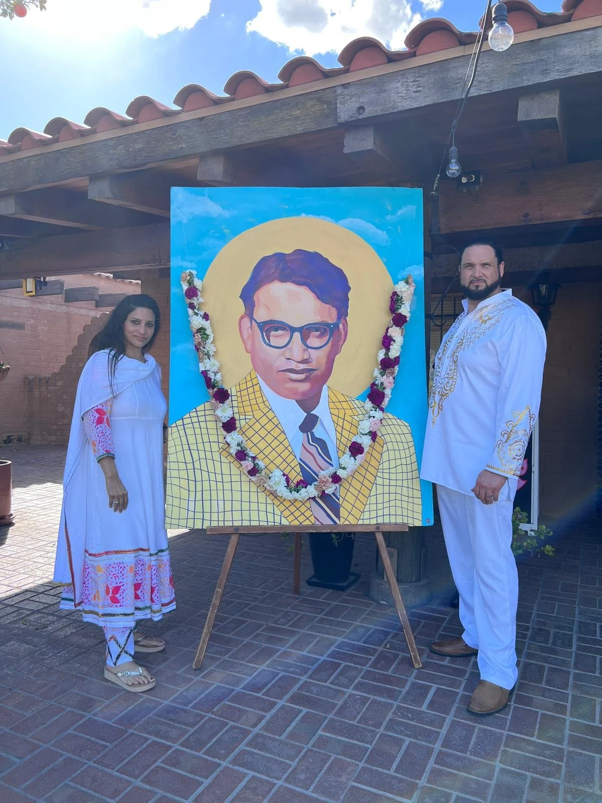 Portrait of Dr. Indu Bhusan Mishra by Michael Che Romero, haloed in gold against an open sky