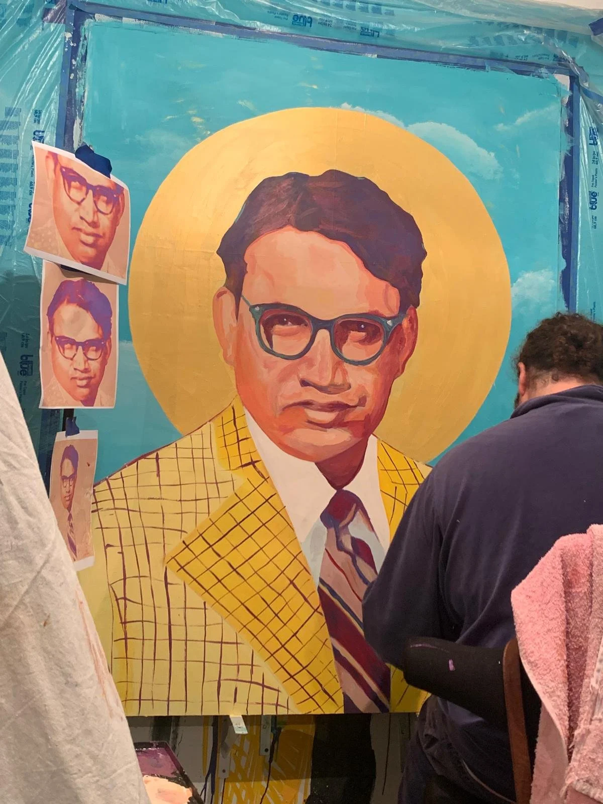 The nearly finished portrait of Dr. Indu Bhusan Mishra beside its reference photos