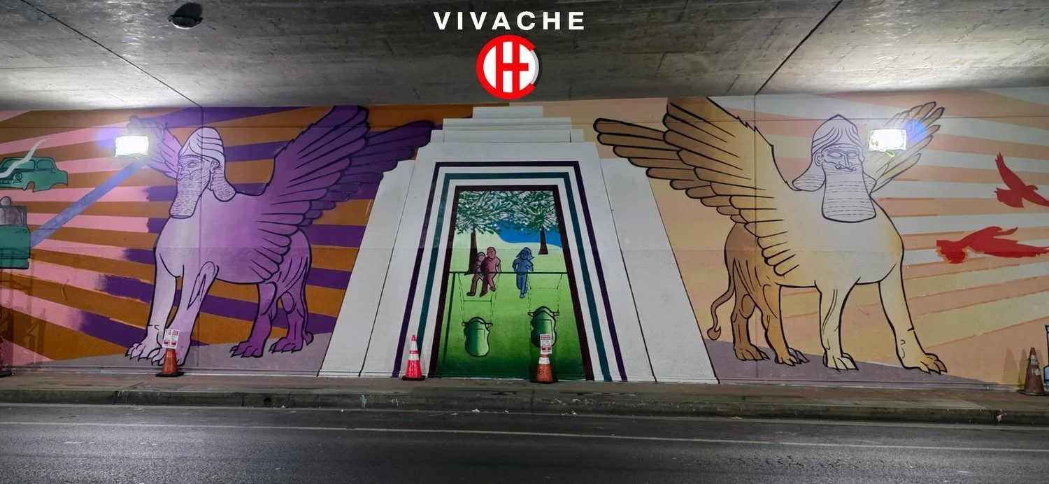 The Model City mural under a freeway bridge in Commerce, CA, with two winged guardians framing an archway, by Vivache Designs