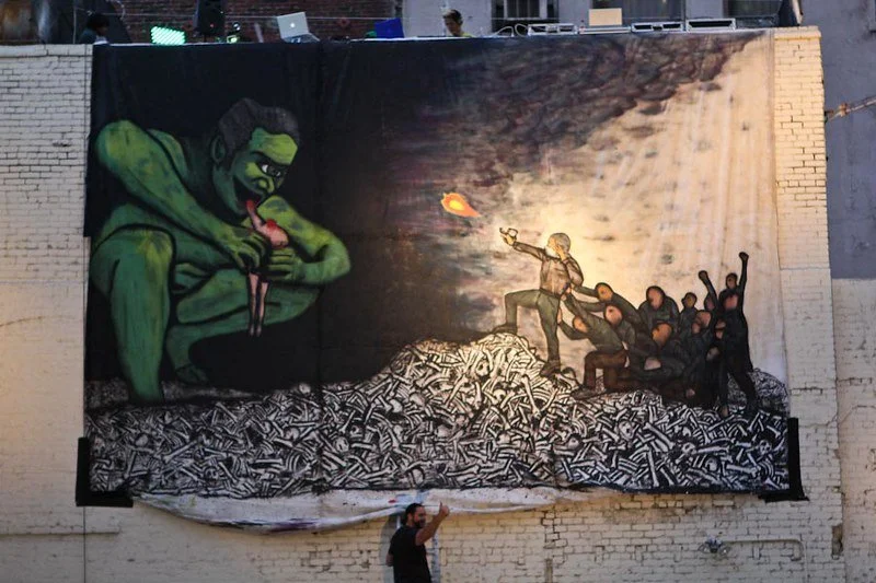 Michael Che Romero beneath his tapestry at Disrupting the Gallery, Los Angeles, 2012