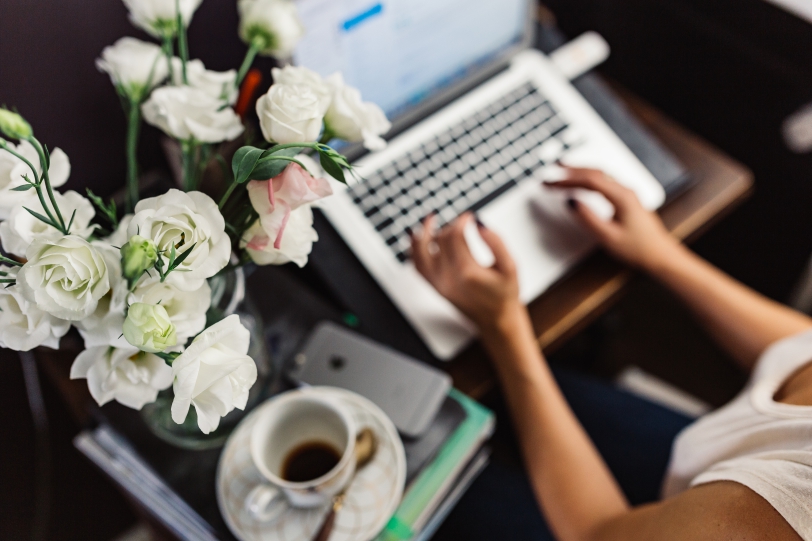 IT freelance writer types on keyboard drinks coffee