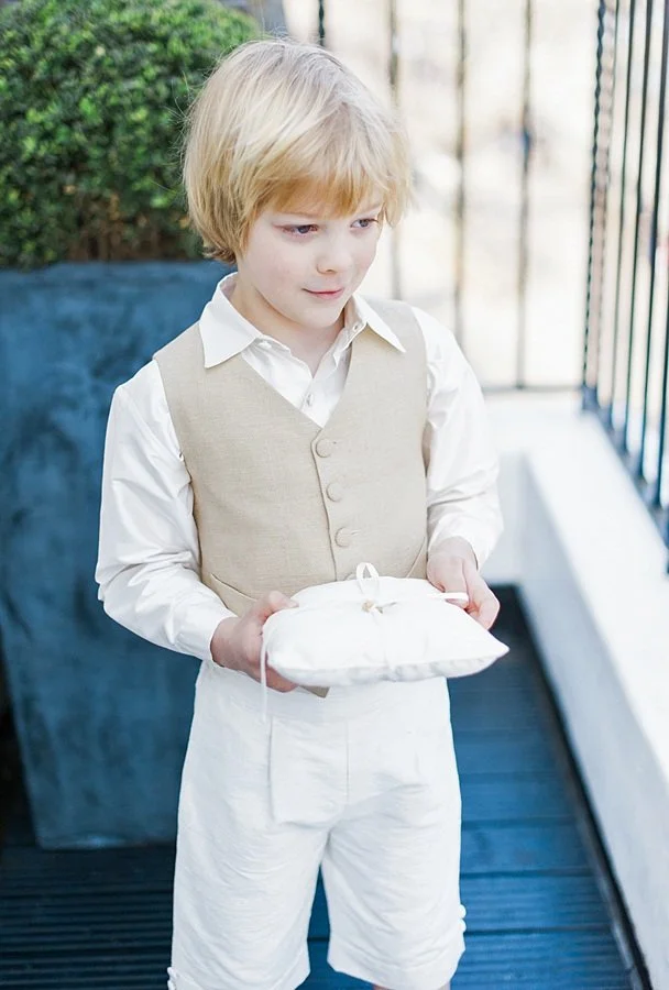 young pageboy wearing a waistcoat holding a wedding ring cushion