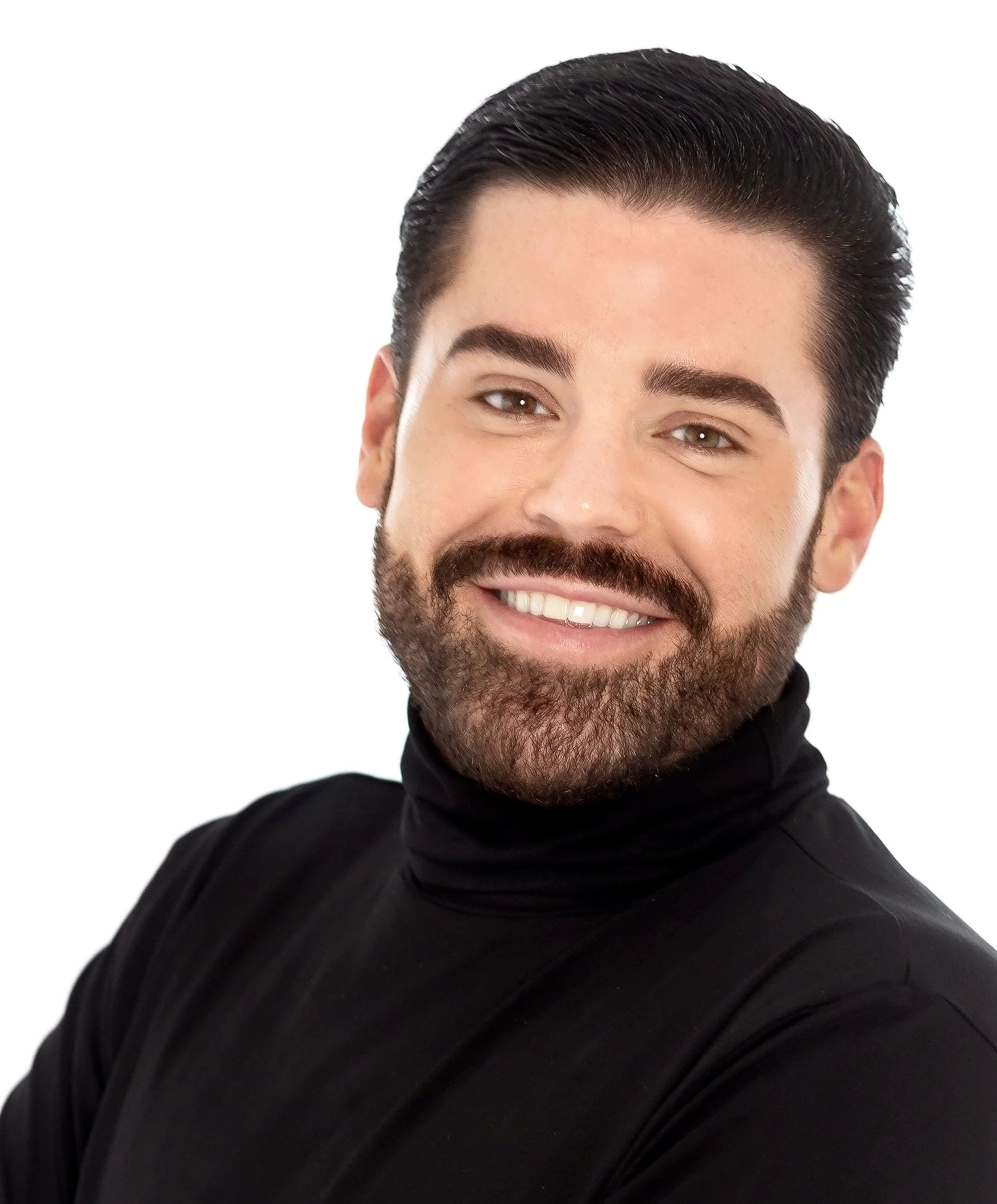 Close-up of a man's smiling face with dark, slicked-back hair, well-groomed beard, and wearing a black turtleneck.
