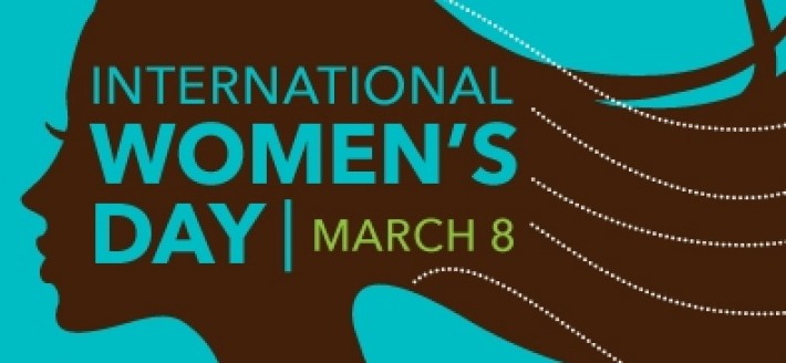 Image Description: A wide-screen image of the dark brown silhouette of a woman laid over a mid-light grey-blue. she faces left and her hair trails over the right side of the picture. The words "INTERNATIONAL WOMEN'S DAY, MARCH 8" overlay the silhouette.