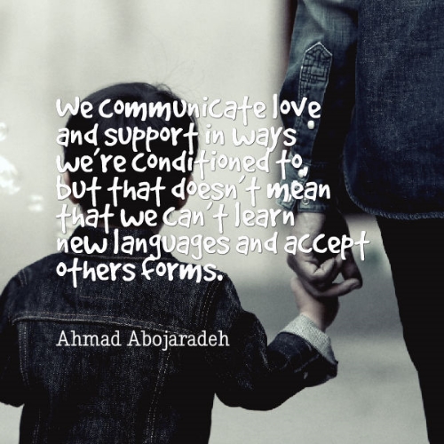Photo Description: A black and white photo, tinged with blue denim which a small boy and an adult wear jackets of as they appear to be walking away. The child is the focus and the adult next to them is mostly out of the picture. The child holds the adults two fore fingers. Ahmad's quote overlays photo "We communicate love and support in ways we're conditioned to, but that doesn't mean that we can't learn new languages and accept other forms".
