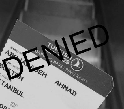 Photo Description: A black and white image of a boarding pass of Ahmad's before a blurry staircase. The word "DENIED" overlays the photo.