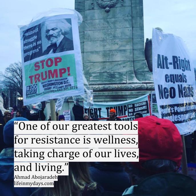 Photo Description: A group of protesters carrying Stop Stump signs in Union Square in Washington DC, with the quote "One of our greatest tools for resistance is wellness, taking charge of our lives, and living.