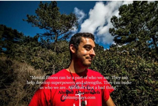 Photo Description: a Bright smile covers the side of my face as I look to picture right in front of bushes and trees and a blue sky above. "Mental Illness can be a part of who we are. They can help develop superpowers and strengths. They can make us who we are. And that's not a bad thing." Quote by Ahmad Abojaradeh. 