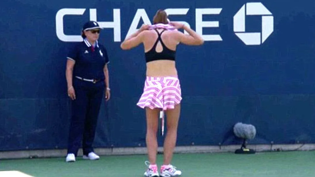 This is the moment Alize Cornet inspired the tennis court umpire to penalize her for removing her top to switch it around.