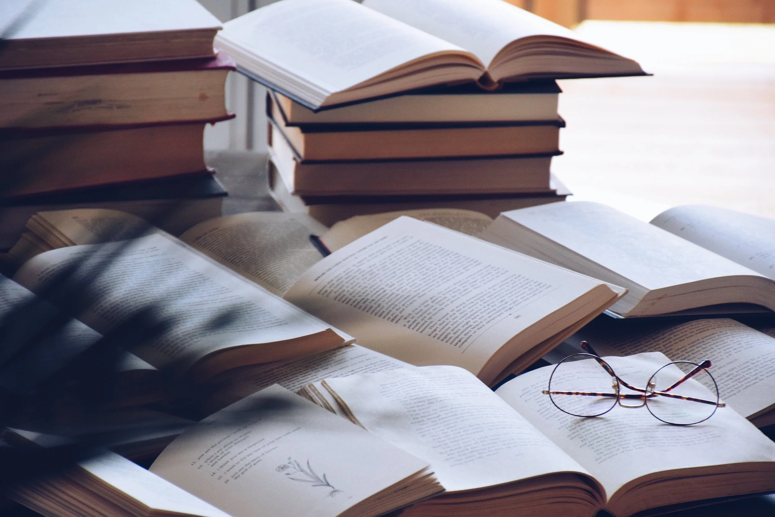 Stack of books with reading glasses