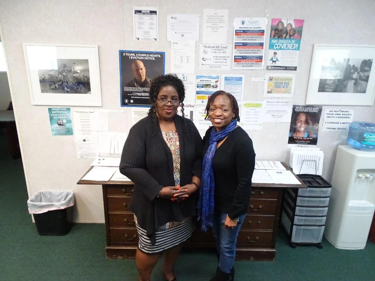 HOW CAN WE HELP? — Spring Hill Resource Center Administrator Shilretha Dixon, left, and Administrative Assistance Wanda Raulerson are ready to help clients who visit the Resource Center. Behind them is a wall of information to help clients navigate various programs to help them find healthcare, housing, jobs, and more. BEACON PHOTO/ELI WITEK