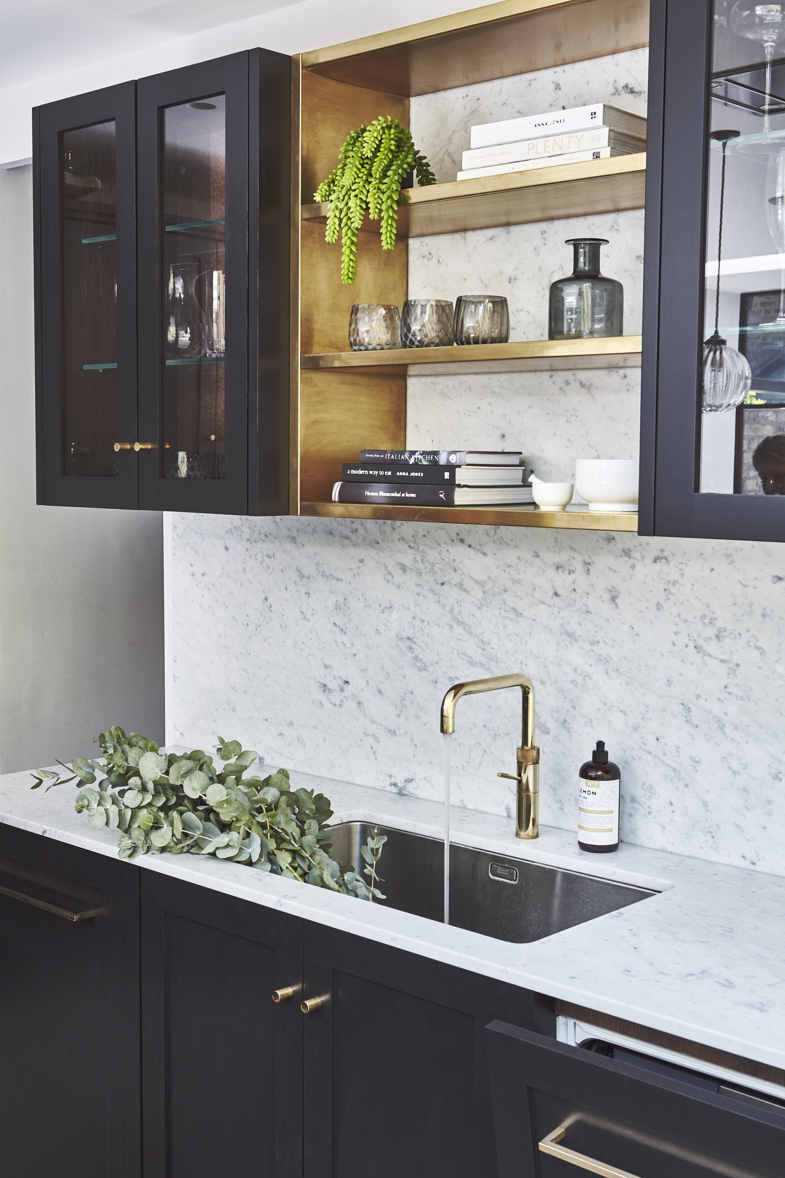Dark kitchen interior design in Clapham with marble splashback and worktop with brass accents