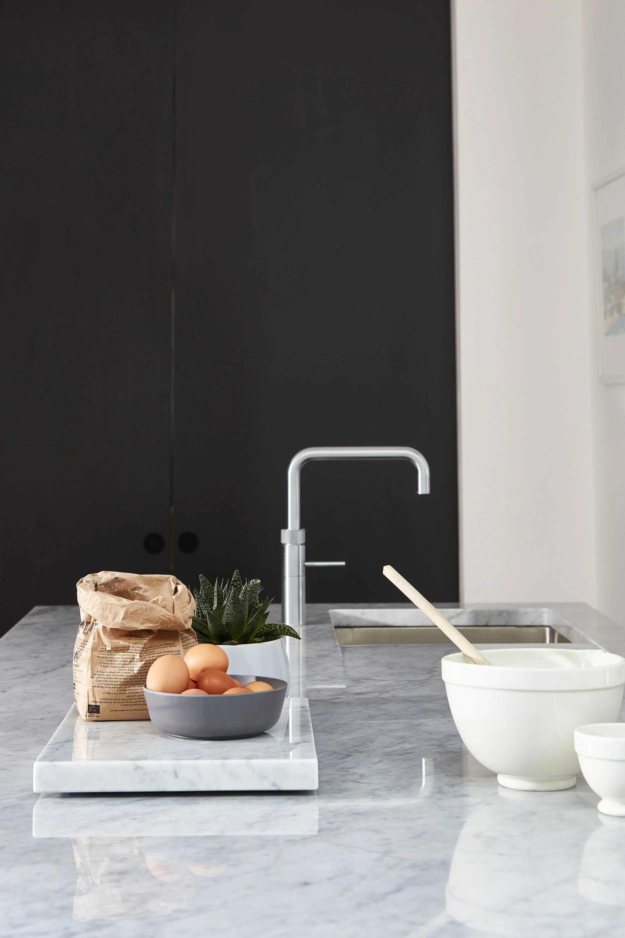 Quooker tap installed in a dark kitchen with marble worktops. Designed by Stanza interior design, Balham
