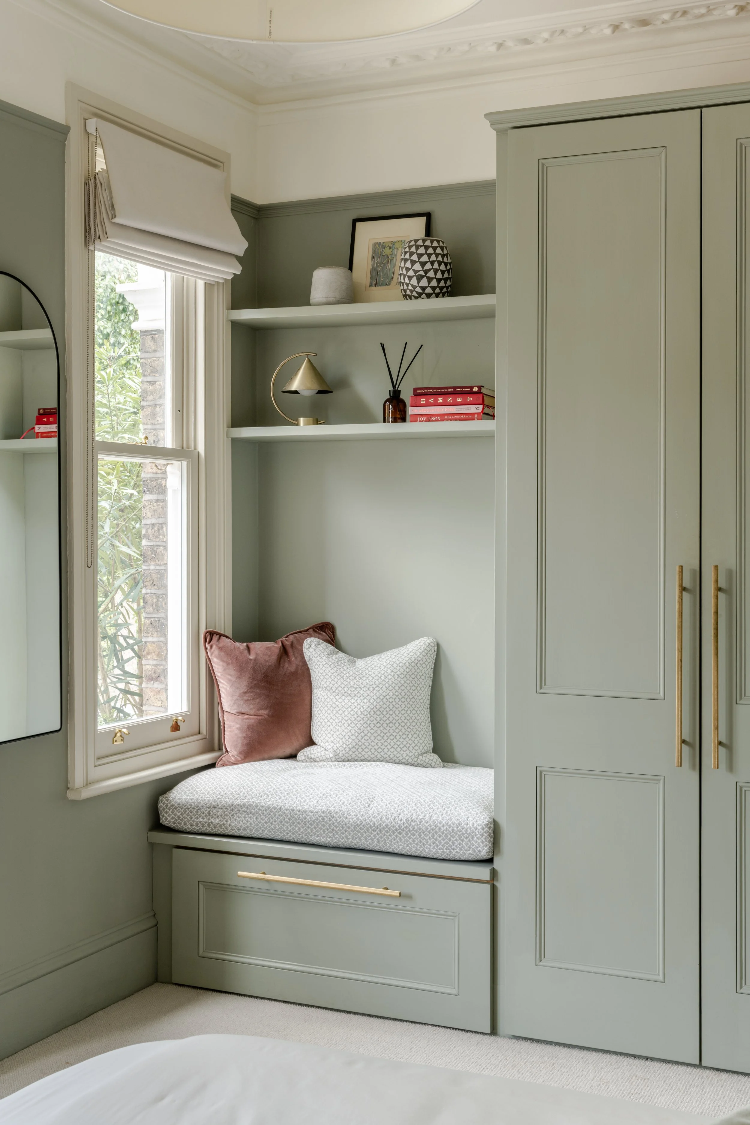 Bespoke wardrobes and joinery for all rooms of the house. With a cushioned window seat and shelving above.