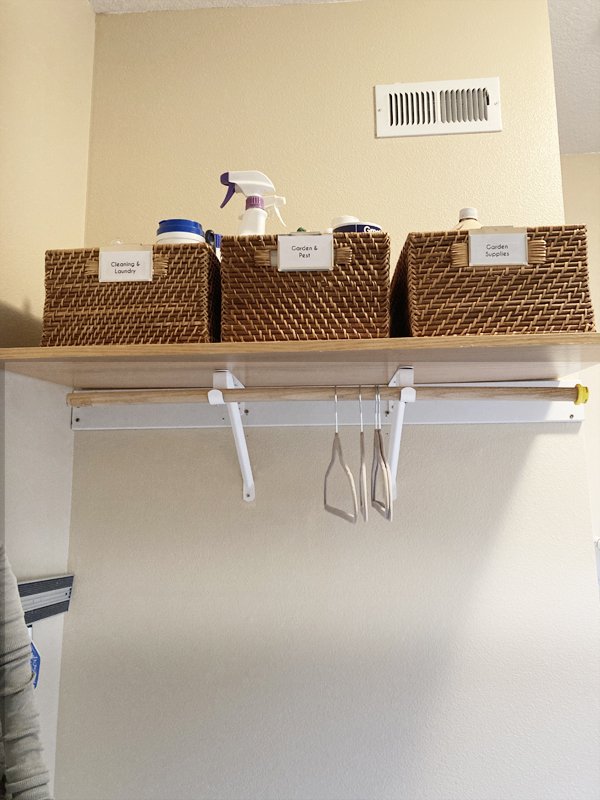 Labeled baskets on shelf above hanging rod