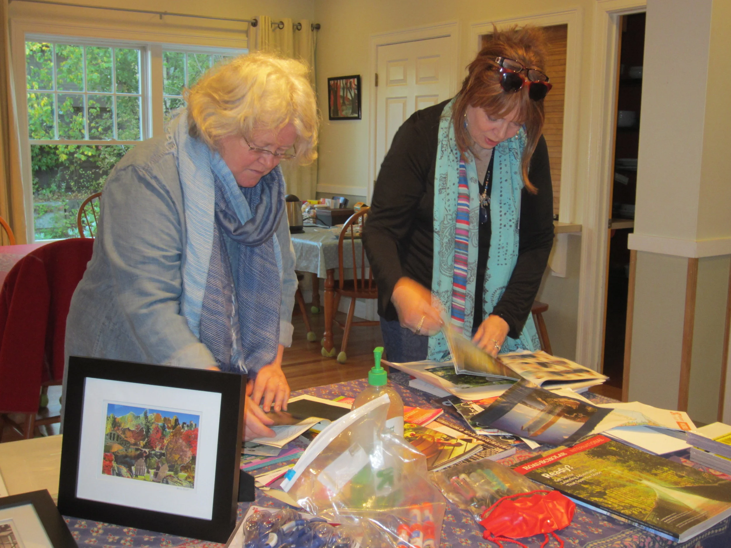 Two NoCa members select images to cut up for their collages.