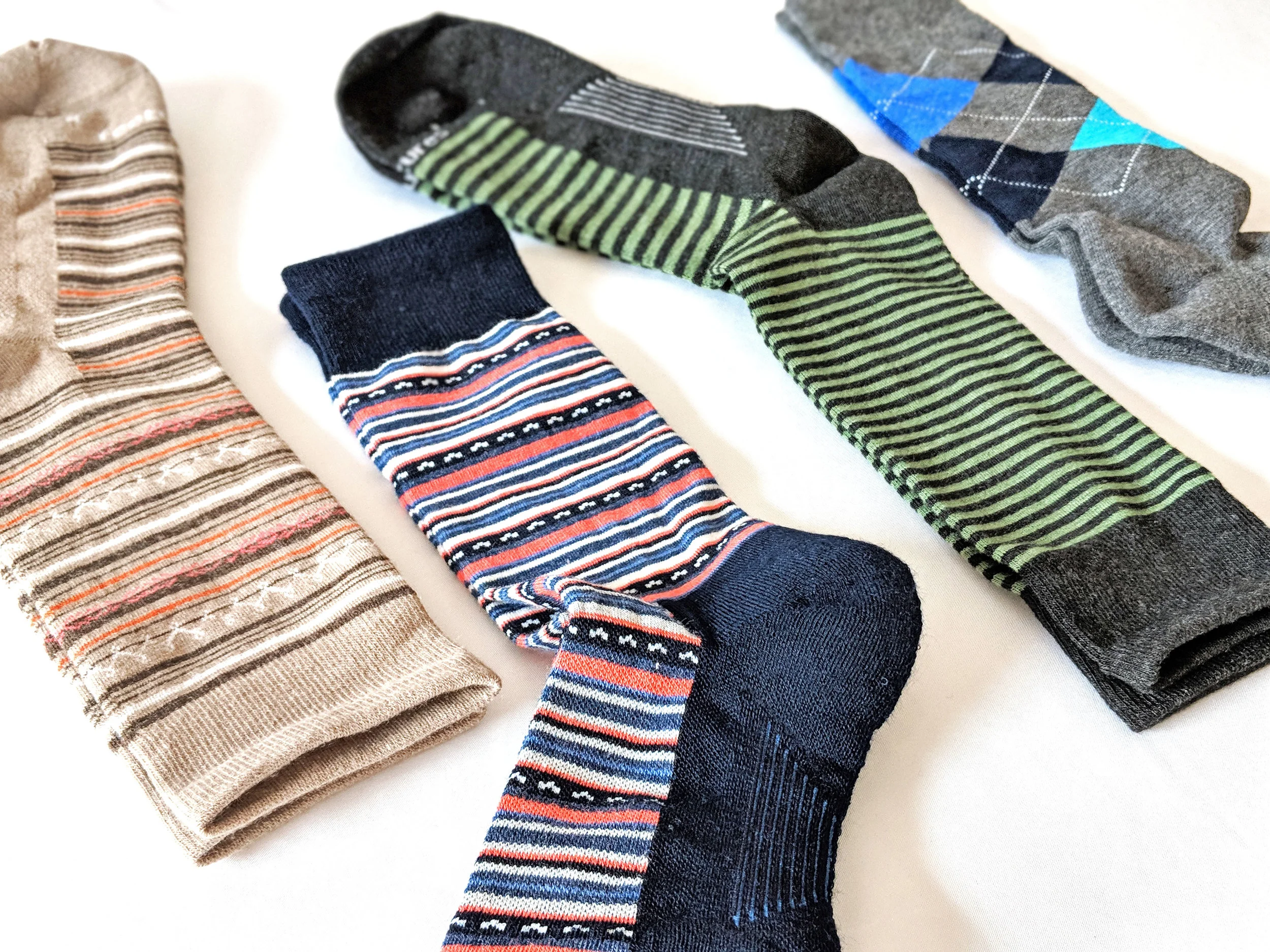 Feetures assorted crew sock styles, left two are women's, right two are men's - Photo Credit: The Sock Review
