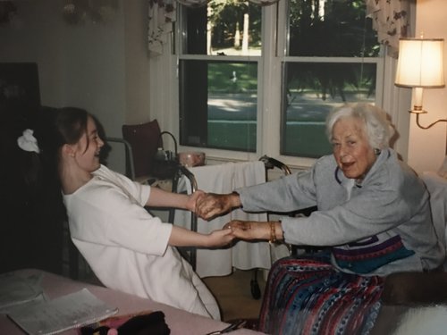 Sarah helping Nana up from her chair.