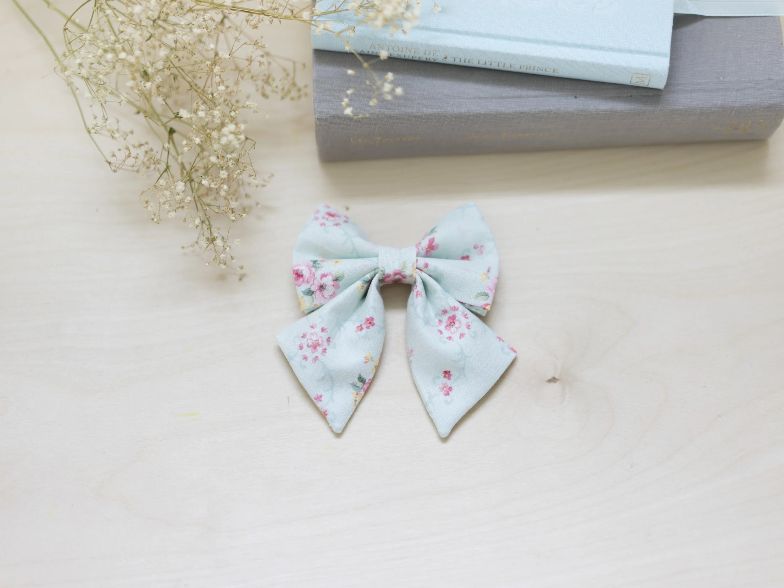 blue floral cat sailor bow accessory flatlay with books