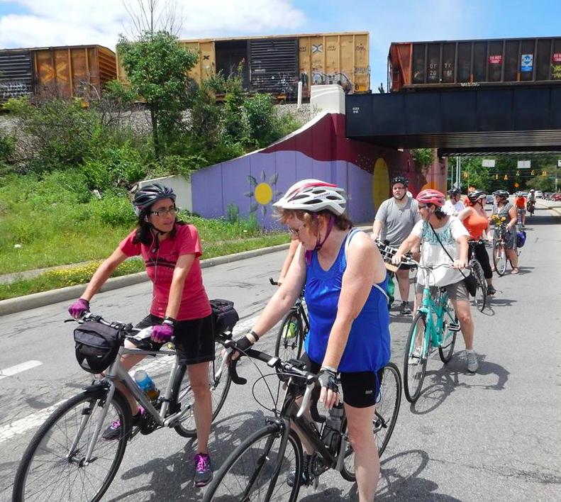 Cyclists chatting with each other at a stop. Photo credit: Keith Lugs