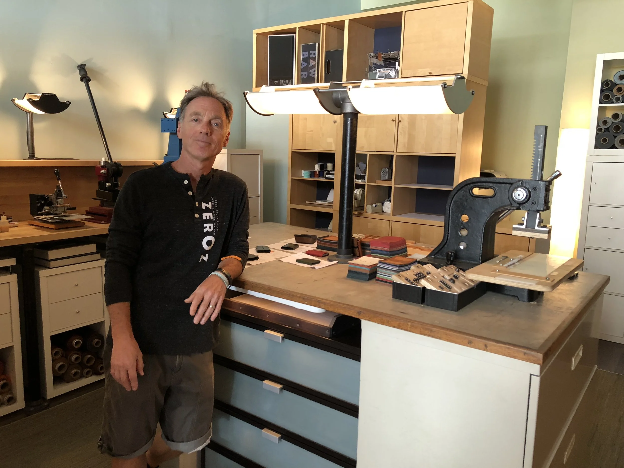 Paul Westrick of zerOz in the wallet production area of his Gay Street retail shop, where artists are constantly churning out his unique, hand-crafted wallets.