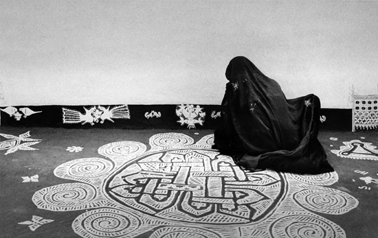 A woman drawing a mandana design, Rajasthan | Modern silver gelatin print | 10.5" x 14.5" | 1980