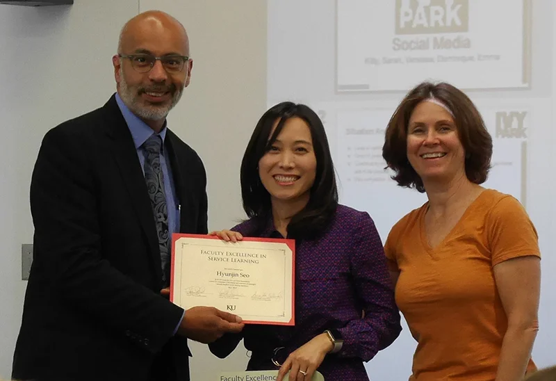 Associate Professor Hyunjin Seo received the 2017 Faculty Excellence in Service Learning Award from the KU Center for Civic and Social Responsibility (CCSR). CCSR Director John Augusto and Assistant Director Linda Dixon made a surprise visit to her J615 Social Media class May 2 to present the award.