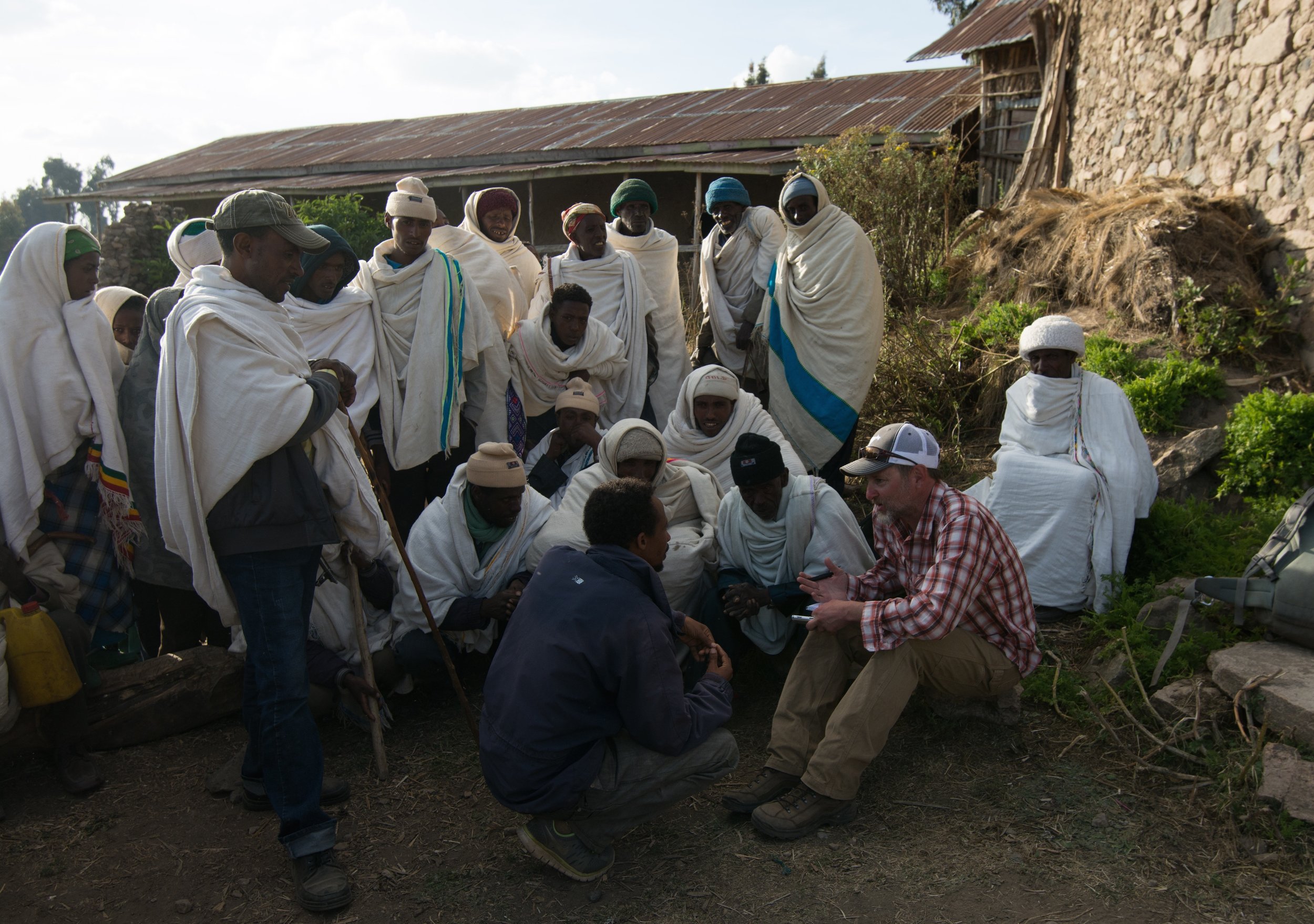 Christian villagers outside a church explain to Welch how they've managed to so thoroughly protect the rich grasslands in their community of 45,000 in the highlands of Ethiopia—a place where most meadows, thickets, moors and swamps are in steep decay. PHOTO CREDIT: Jeff Kerby