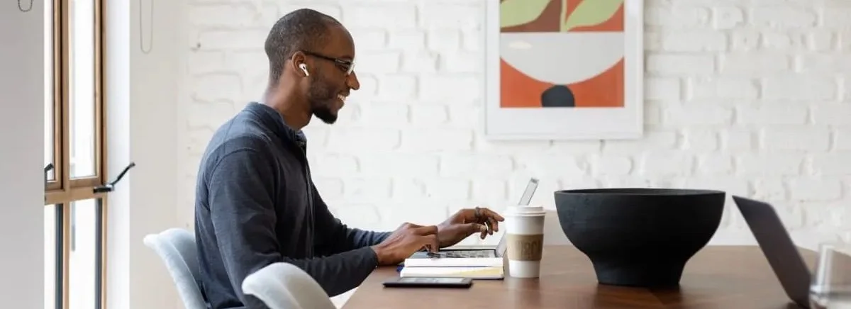 Man working on a laptop in a modern cafe setting