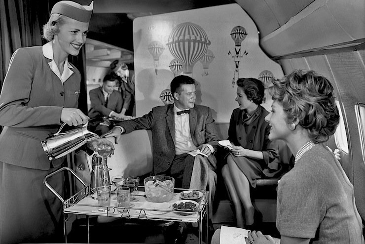 1950s PanAm stewardess using a bar cart to serve passengers.