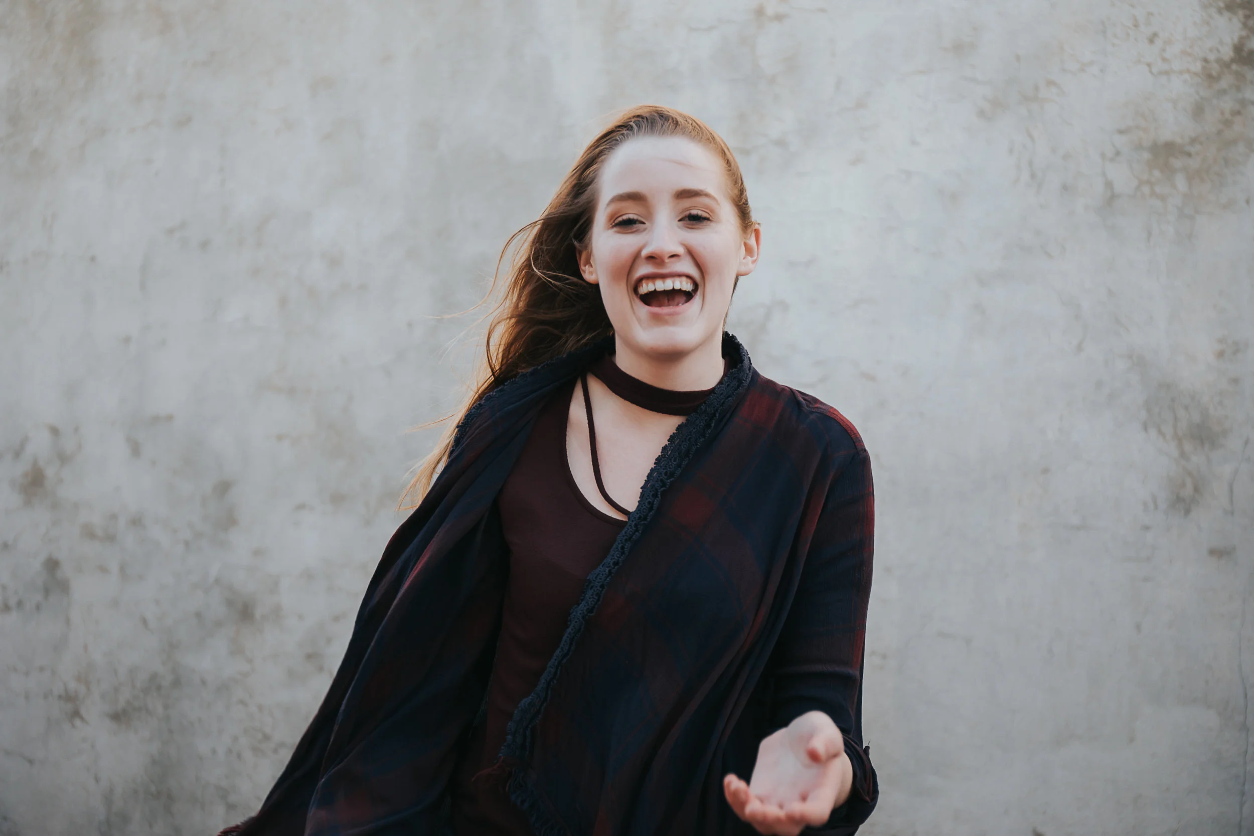 Senior laughs in alley during senior photos in the Crossroads District.