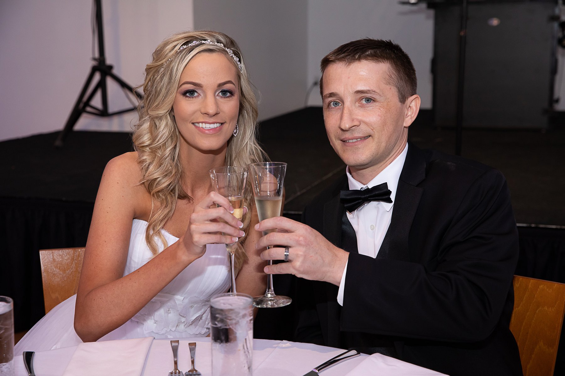 Bride and groom smile and toast by Merry Ohler | Best Kansas City Wedding Photographer