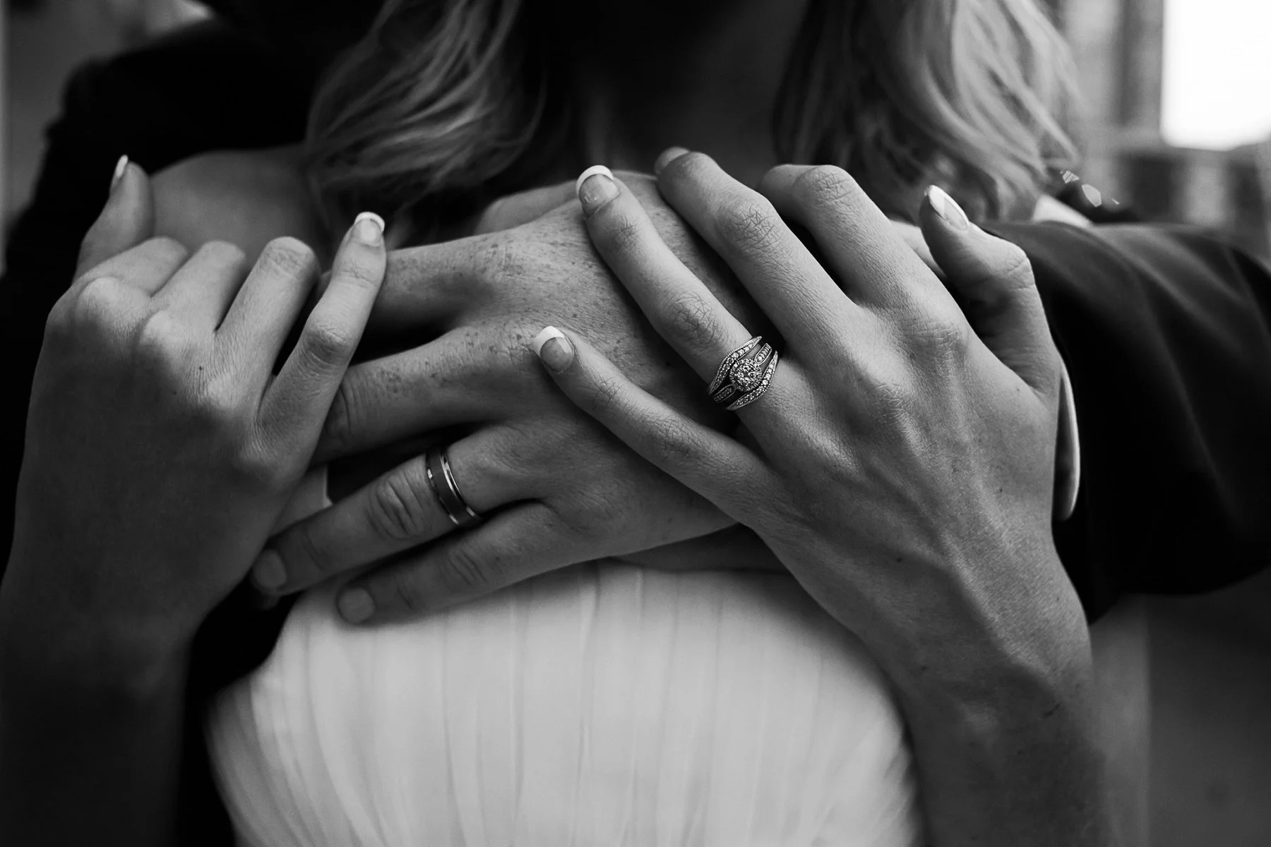 Black and white photo of bride and groom’s hands at Power and Light District in Kansas City. © Merry Ohler Creative, 2019. Image by Merry Ohler, who is the best wedding photographer in Kansas City.