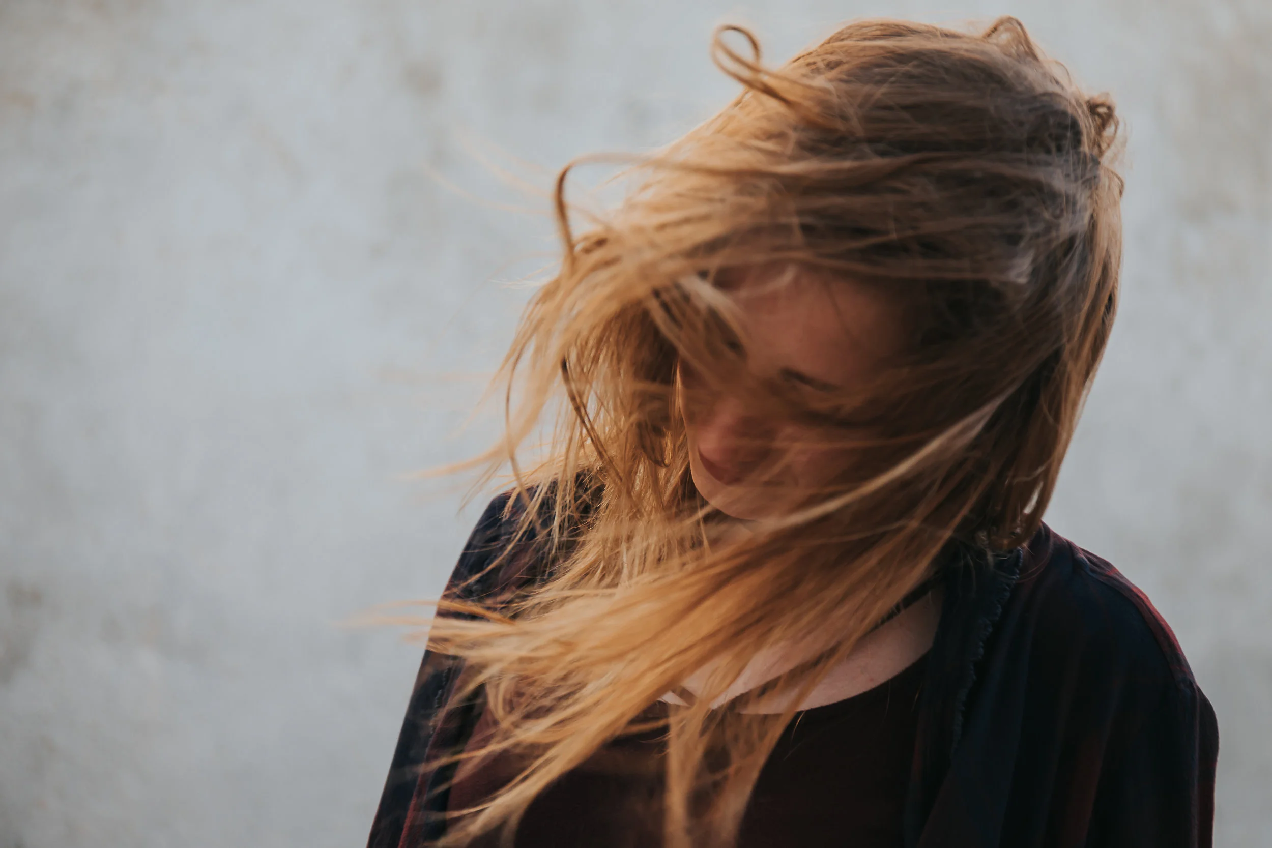 Teen girl’s hair blows wildly in the wind. © Merry Ohler Creative, 2019. Photo by Merry Ohler, wedding photographer Kansas City.
