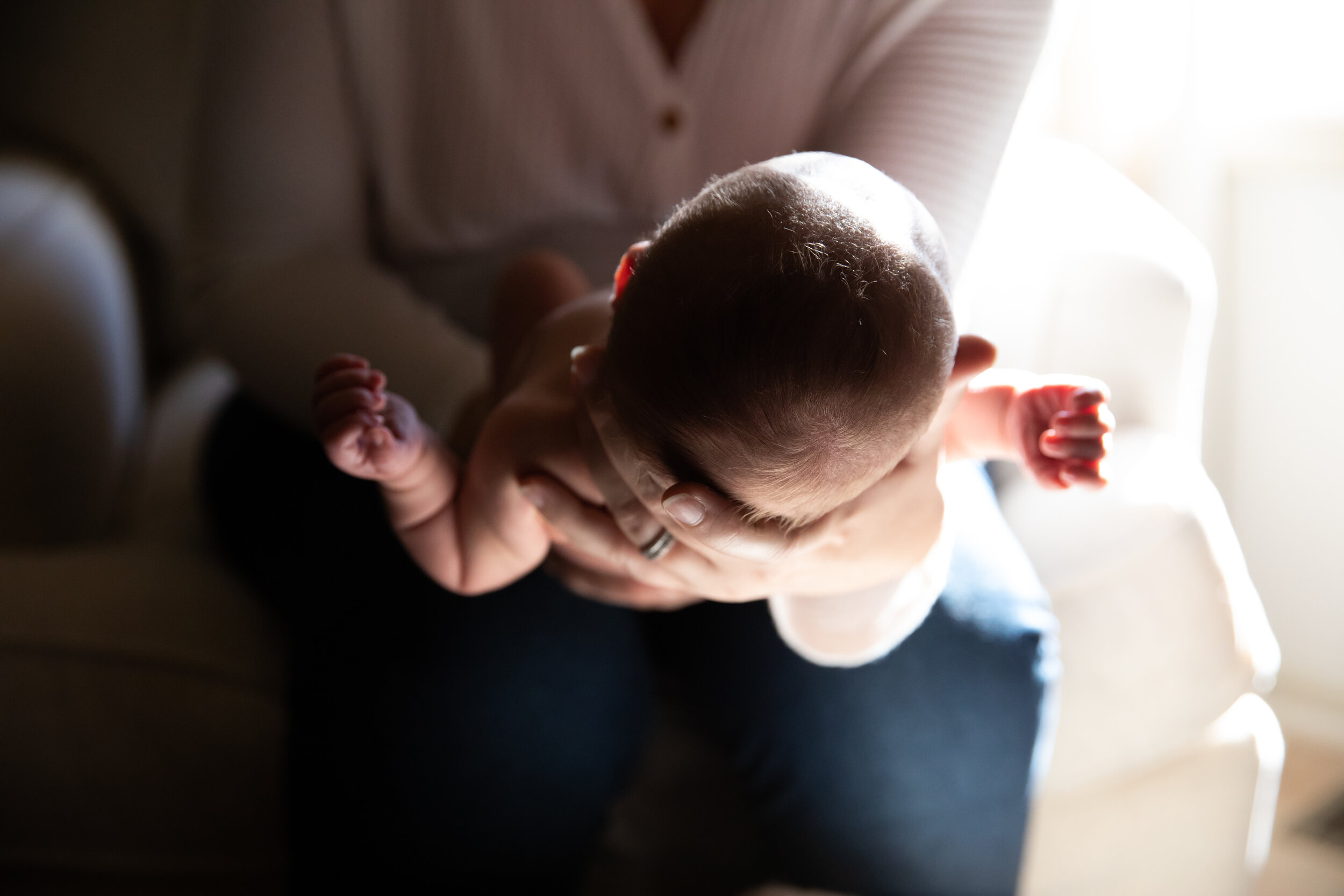 Father holds baby during at home newborn photos in Liberty, MO.