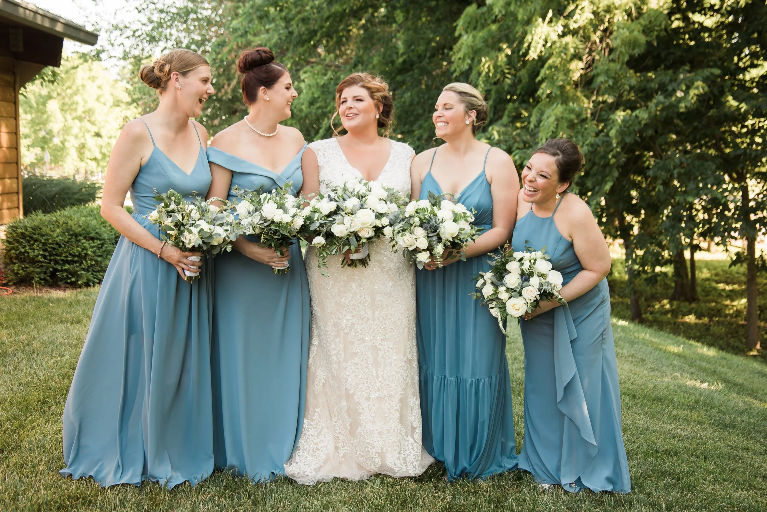 Bride and bridesmaids laugh at Mahaffie Stagecoach wedding in Lenexa.