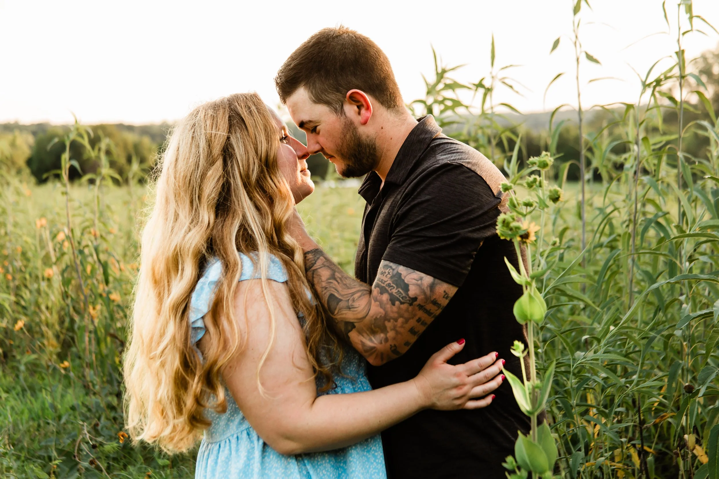 Couple embraces in wildflowers during Kansas City engagement photography session at Shawnee Mission Park.