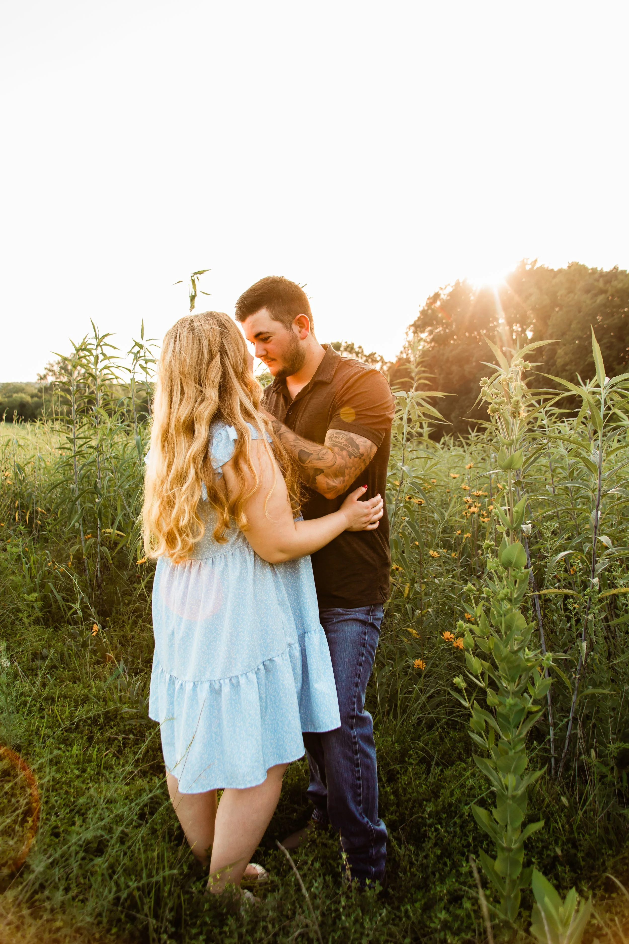 Engaged couple kissing in wildflowers in Shawnee Mission, KS.