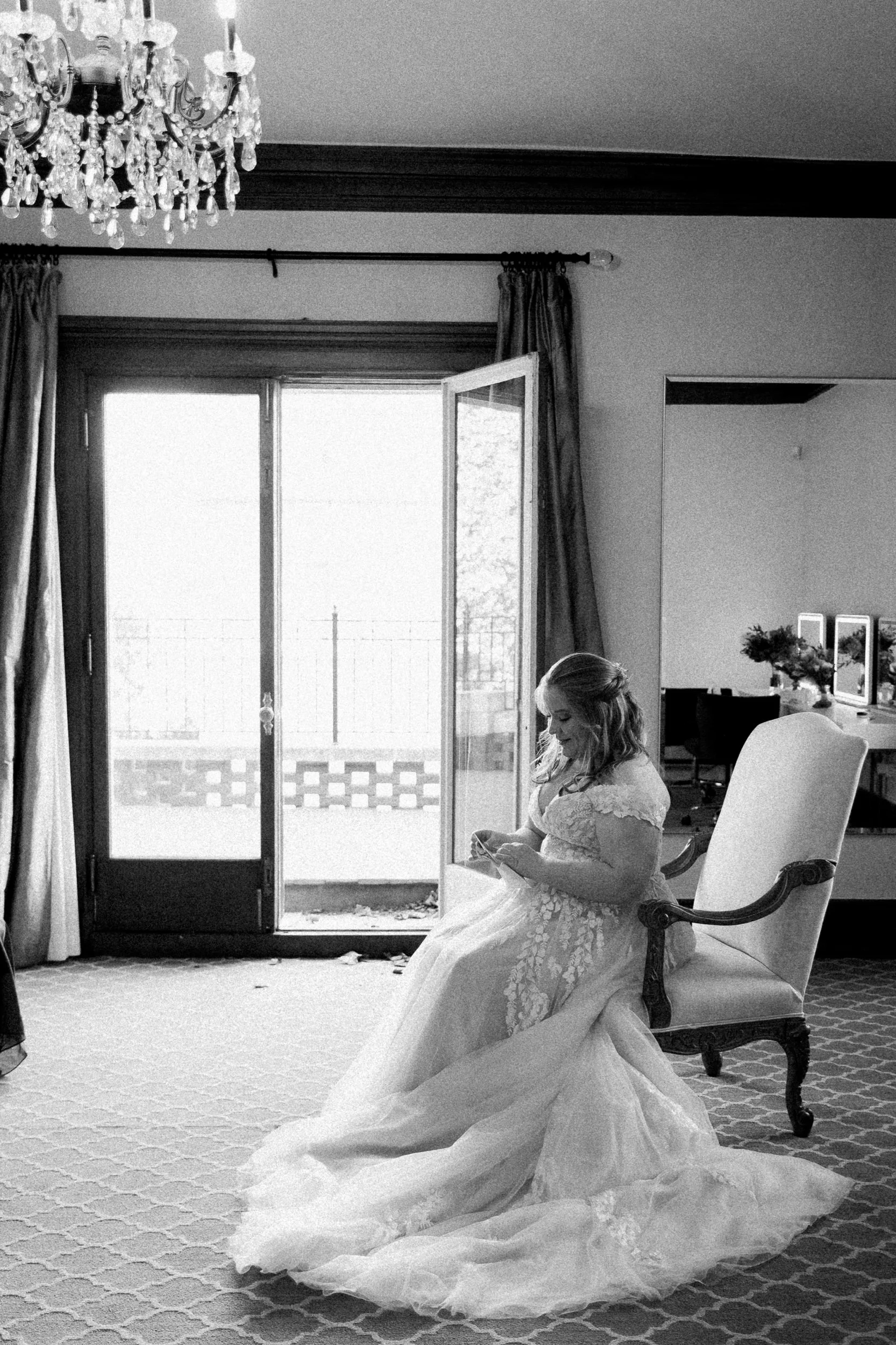 Black and white photo of bride reading a letter from the groom at Loose Mansion in Kansas City.