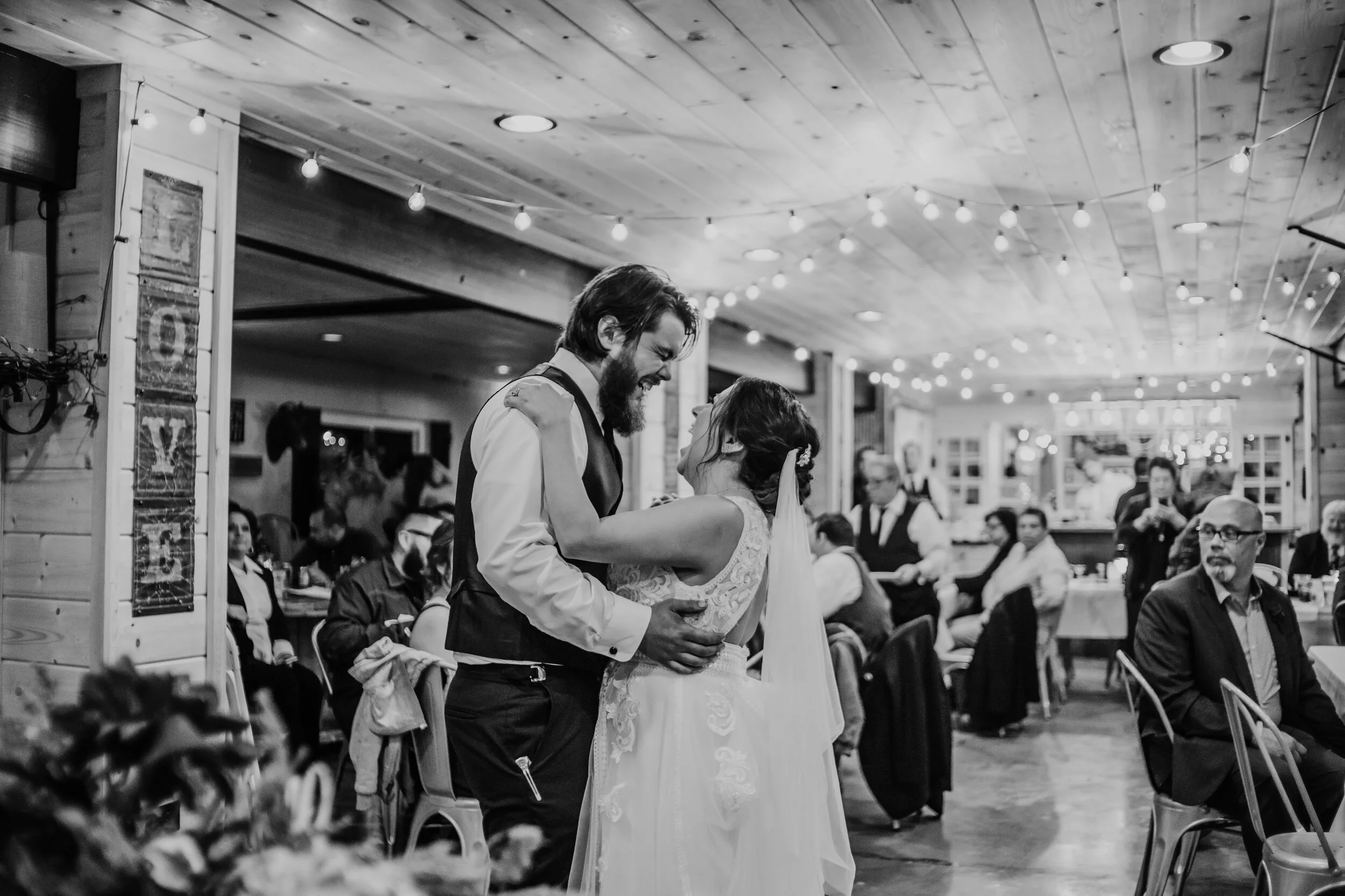 Bride and groom dance as guests look on during wedding in Lenexa, KS.