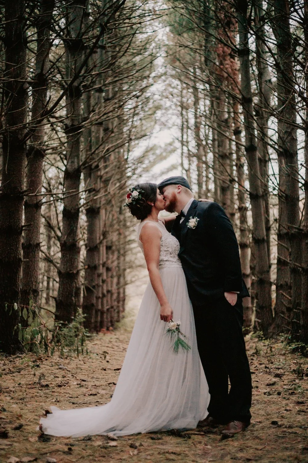 Bride and groom kiss in winter woods during Kansas City elopement in Blue Springs, Missouri.