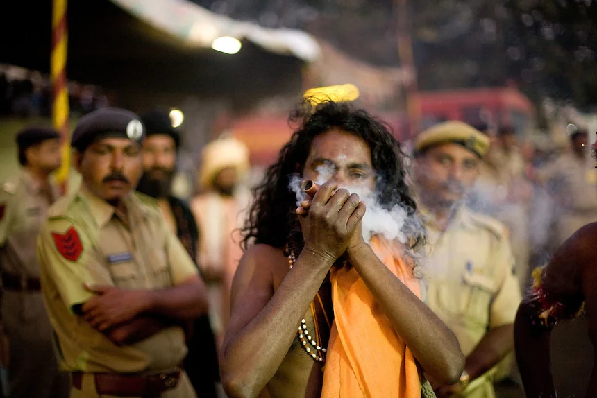 Police tolerates the use of Cannabis while a sadhu smokes in front of them, during Kumbh Mela.