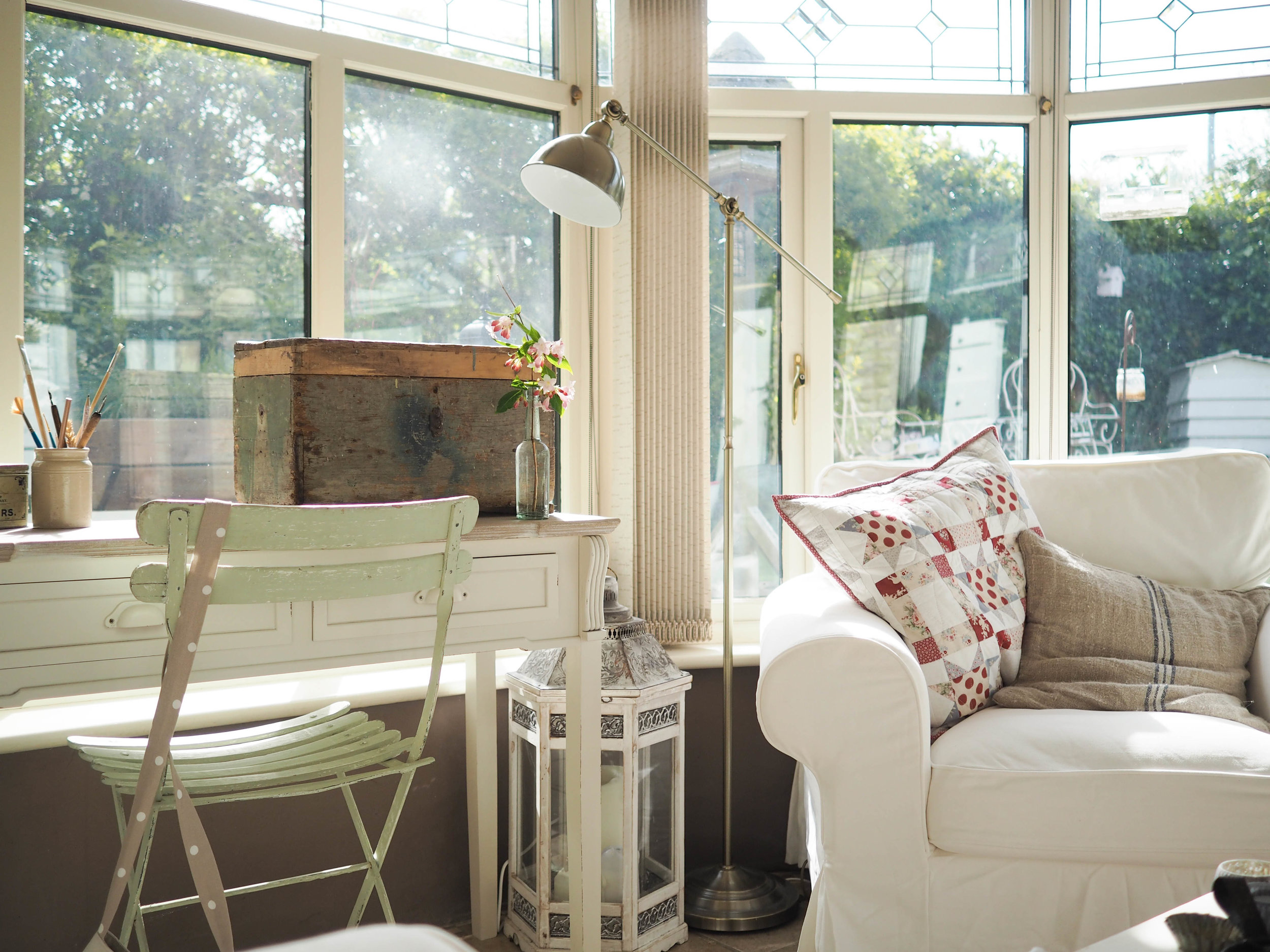 The conservatory. The old wooden box houses my painting supplies. The patchwork cushion was a gift from my mum (it is a Tilda pattern using Tilda fabric). She made two cushions and a matching quilt for my 40th birthday and I love them!