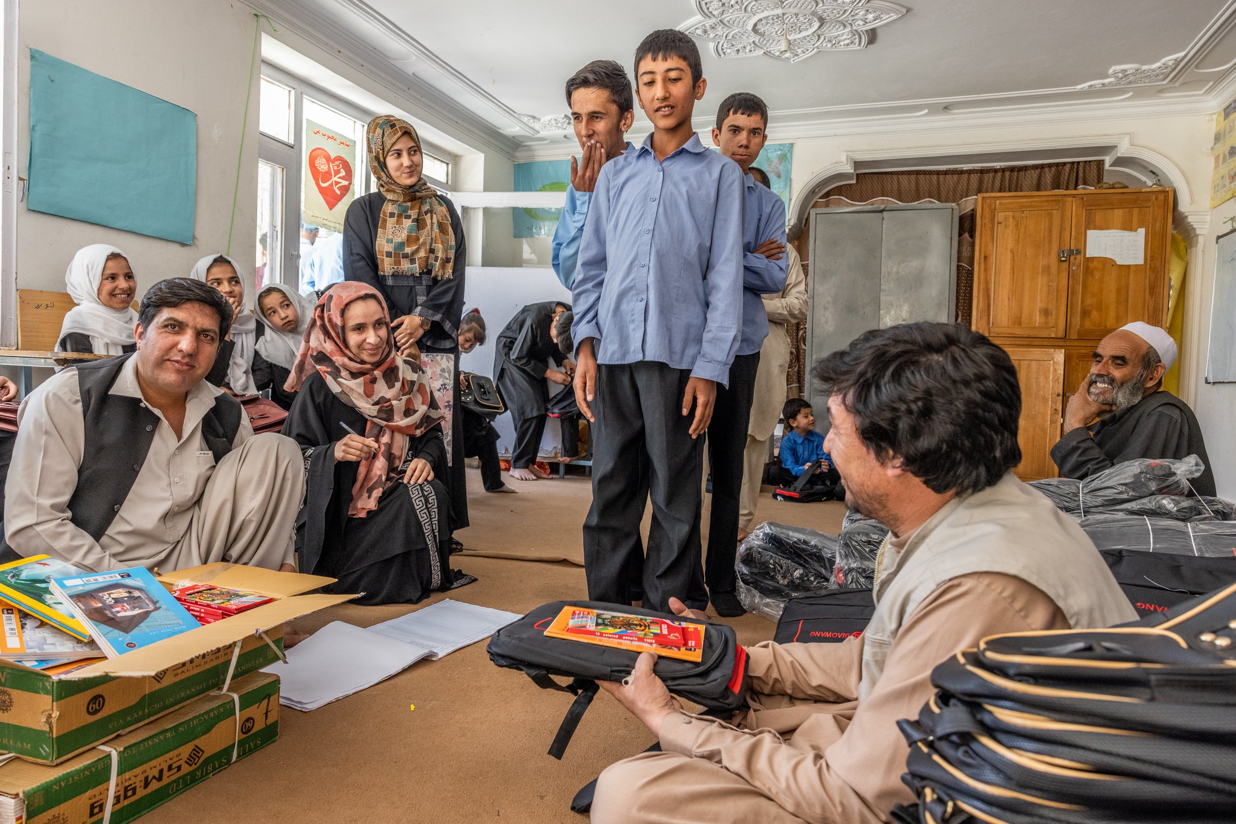  May 2022. Deaf students line up to receive books, pencils and bags from school administrator. Kabul, Afghanistan. 