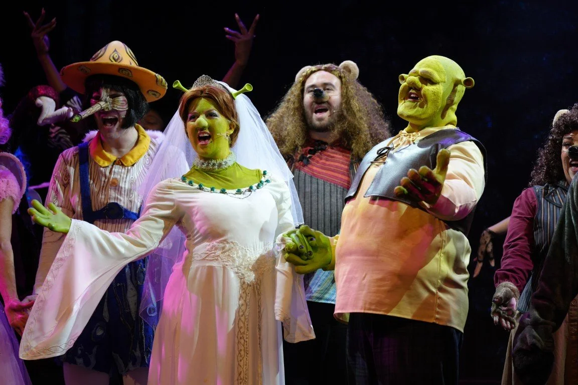 Shrek and Princess Fiona (in a wedding dress) hold hands and sing during the finale in Phoenix Theatre’s Shrek The Musical (Aberdeen, 2025).