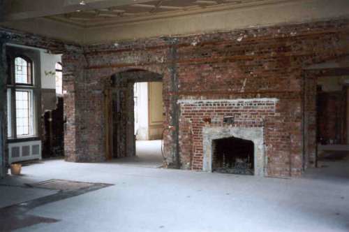  This is the same room, from about the same point of view, with the walls and false ceiling taken out and the floor covered. Note how the original fireplace had been bricked in and made much smaller. 