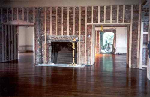  Now the fireplace has been opened back to its huge original size, the hardwood floor replaced and batten strips added to the walls, ready for the new paneling. 