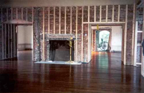 Now the fireplace has been opened back to its huge original size, the hardwood floor replaced and batten strips added to the walls, ready for the new paneling.